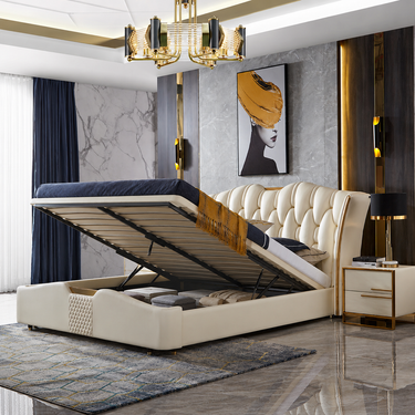 A luxury cream tufted storage bed with its lift-up mattress platform open, showcasing the spacious interior. The bed is styled in a modern, high-end bedroom with gray marble walls, a dark blue curtain, a gold chandelier, and a matching cream nightstand.