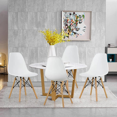 Dining room with a round table and white chairs against a gray tiled wall.
